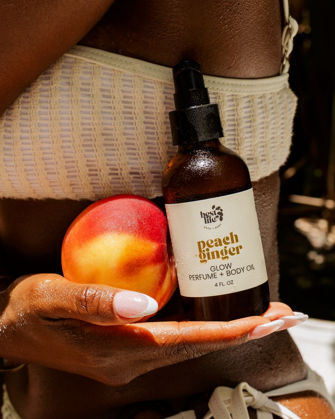 A person in a white bikini holding our Peach Ginger Body Oil